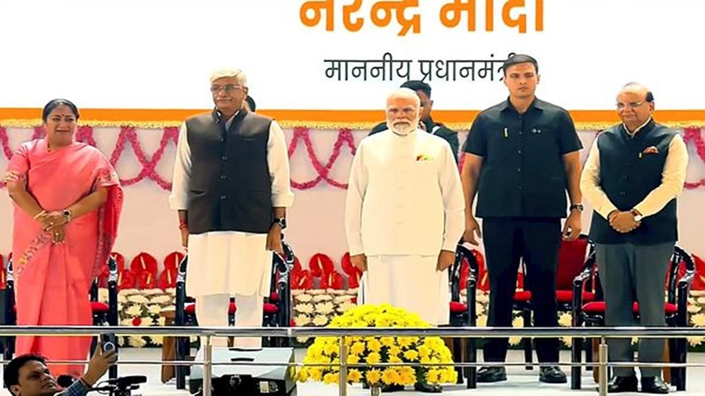 7 नवंबर, 2025, राष्ट्रीय गीत 'वंदे मातरम' के 150 वर्ष पूरे होने पर नई दिल्ली के इंदिरा गांधी इंडोर स्टेडियम में आयोजित कार्यक्रम के दौरान प्रधानमंत्री नरेंद्र मोदी, दिल्ली के उपराज्यपाल वीके सक्सेना, मुख्यमंत्री रेखा गुप्ता और केंद्रीय संस्कृति एवं पर्यटन मंत्री गजेंद्र सिंह शेखावत। (@NarendraModi/YT via PTI Photo) 7 नवंबर, 2025, राष्ट्रीय गीत 'वंदे मातरम' के 150 वर्ष पूरे होने पर नई दिल्ली के इंदिरा गांधी इंडोर स्टेडियम में आयोजित कार्यक्रम के दौरान प्रधानमंत्री नरेंद्र मोदी, दिल्ली के उपराज्यपाल वीके सक्सेना, मुख्यमंत्री रेखा गुप्ता और केंद्रीय संस्कृति एवं पर्यटन मंत्री गजेंद्र सिंह शेखावत। (@NarendraModi/YT via PTI Photo)