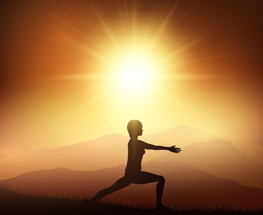 Female in yoga position against sunset landscape