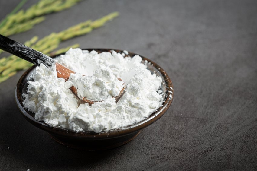 white rice flour on small bowl with rice plant