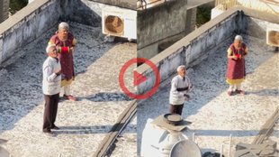 Elderly couple in Gujarat flying kites together on rooftop