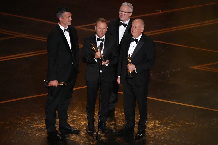 Eric Saindon, from left, Richard Baneham, Daniel Barrett, and Joe Letteri accept the award for visual effects