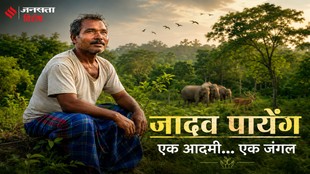 हरियाली से घिरे जंगल में बैठे जादव पायेंग, जिनके पीछे वन्यजीव दिखाई दे रहे हैं।